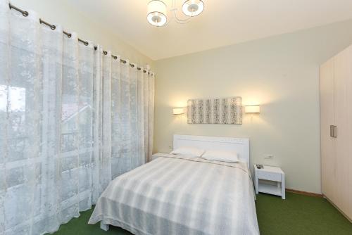 um quarto branco com uma cama e uma janela em Vila Levita em Palanga