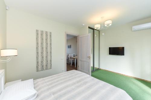a bedroom with a bed and a flat screen tv at Vila Levita in Palanga
