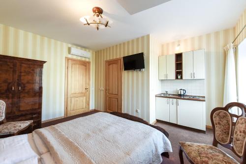 a hotel room with a bed and a kitchen at Vila Levita in Palanga
