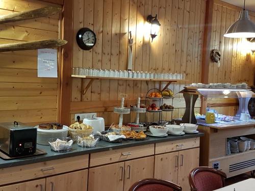 eine Küche mit einem Buffet mit Speisen auf der Theke in der Unterkunft Hotel du lac des Corbeaux in La Bresse