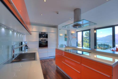 a kitchen with a counter with a sink and some windows at Sant’Andrea Penthouse in Menaggio