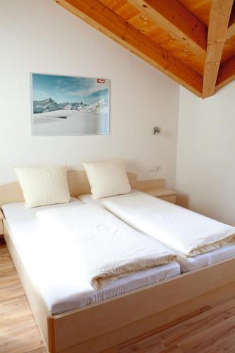a bed in a room with a wooden ceiling at Apart Benita in Nauders