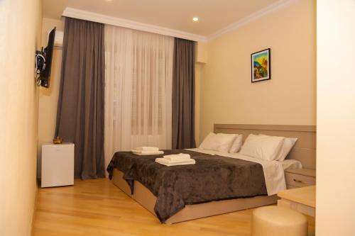 ein Schlafzimmer mit einem Bett in einem Zimmer in der Unterkunft Holiday Rooms in Tbilisi City