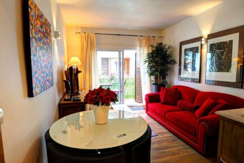 シッチェスにあるOlivia Apartment by Hello Homes Sitgesのリビングルーム(赤いソファ、テーブル付)