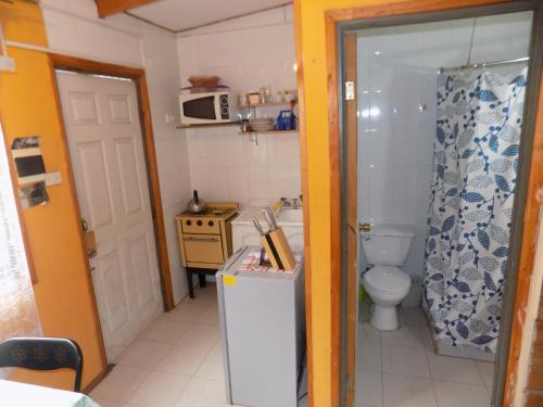 a small kitchen with a refrigerator and a toilet at Alojamiento económico a pasos del Jumbo! in La Serena