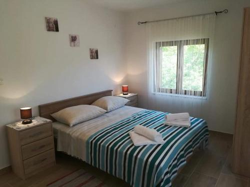 a bedroom with a bed with two towels on it at Apartman Nina in Turanj