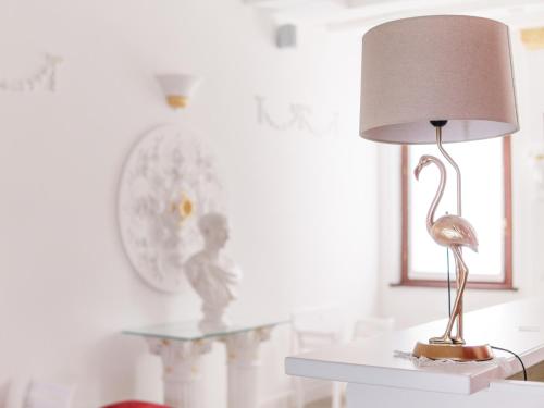 a lamp on a table with a bird on it at Villa Marini Trevisan in Aviano