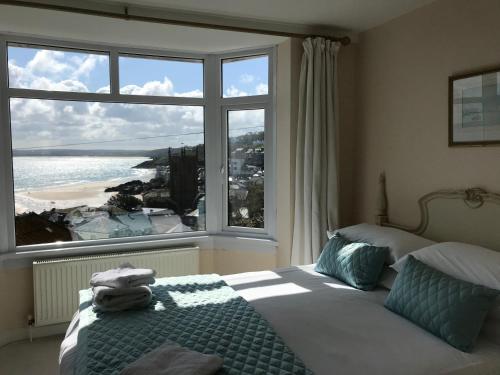 een slaapkamer met een bed en een groot raam bij Palma Guest House in St Ives