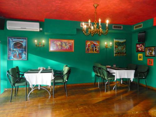 a dining room with two tables and a green wall at Villa Park in Mostar