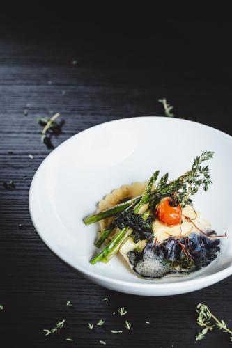a white plate with a dish of food on a table at Gutwinski Hotel in Feldkirch