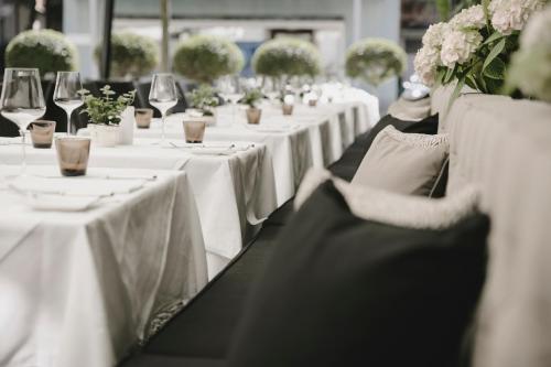 a row of tables with white table linens and flowers at Gutwinski Hotel in Feldkirch