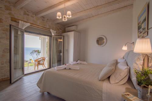 a bedroom with a bed with a view of the ocean at Paxos Sunrise Villas in Gaios
