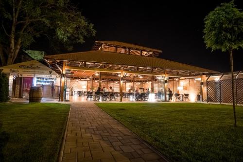 a building with people sitting outside at night at The Dome Hotel in Satu Mare