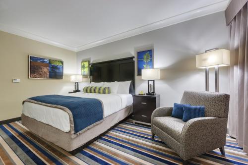 een hotelkamer met een bed en een stoel bij Cypress Bayou Casino Hotel in Franklin