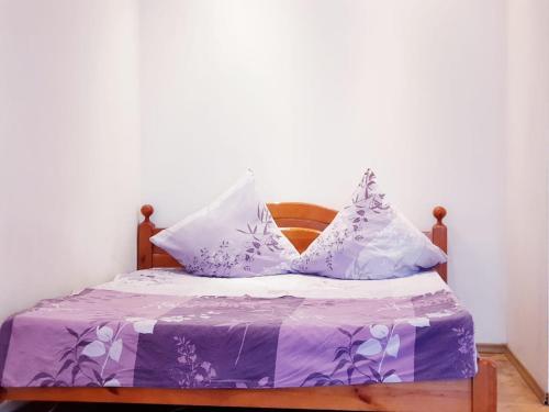 モスクワにあるАпартаменты улица Зацепаの紫と白のシーツと枕が備わるベッド1台