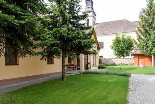 a house with a tree in the yard at Althaus Vendégház in Németkér