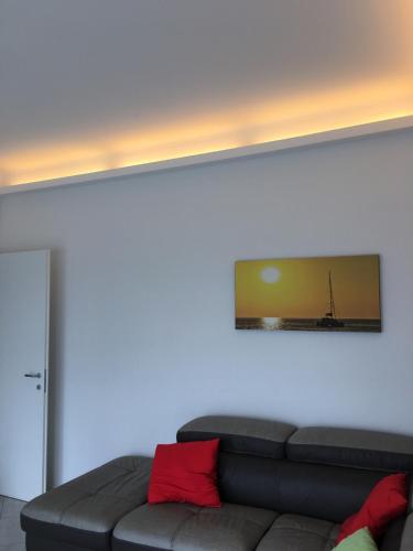 a living room with a couch and a picture on the wall at Appartamento sul porto in Loano