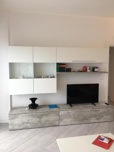 a living room with a tv and white cabinets at Appartamento sul porto in Loano
