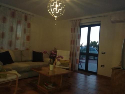 a living room with a couch and a table and a chandelier at villa peppino in Montallegro