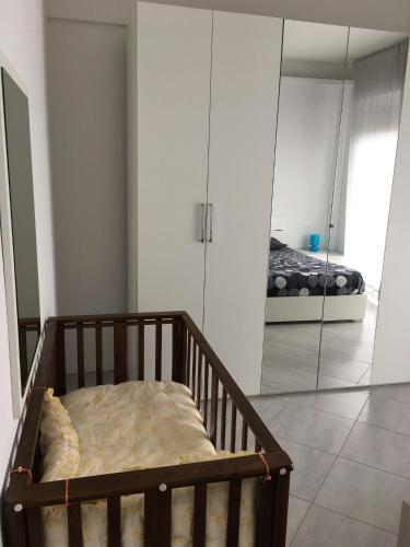 a bedroom with a crib and a bed in a mirror at Appartamento sul porto in Loano