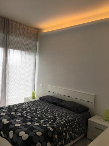 a bedroom with a black and white bed and a window at Appartamento sul porto in Loano