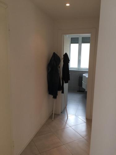 a hallway with an open door with clothes hanging on a wall at Appartamento sul porto in Loano
