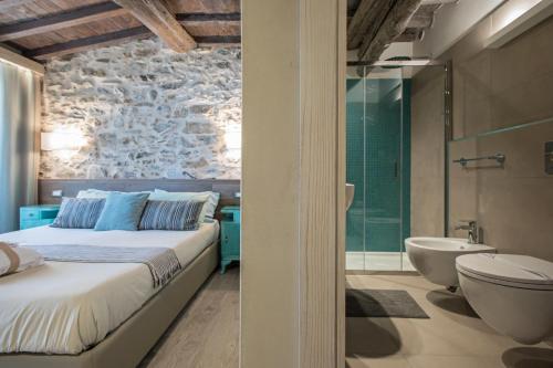 a bedroom with a bed and a tub and a sink at Stellio Affittacamere - Guest House in Riomaggiore