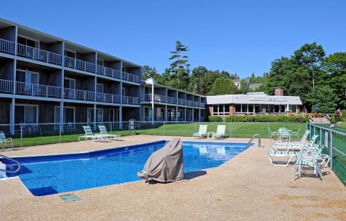 a patio area with a pool and a tennis court at Kimball Terrace Inn in Northeast Harbor