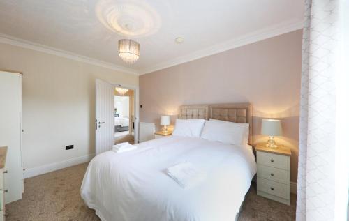 a hotel room with a white bed and white walls at LLwyn Country House in Llanelli
