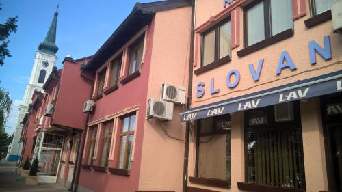 un edificio con un cartello per un negozio con una torre di Business Club Selenča a Bač