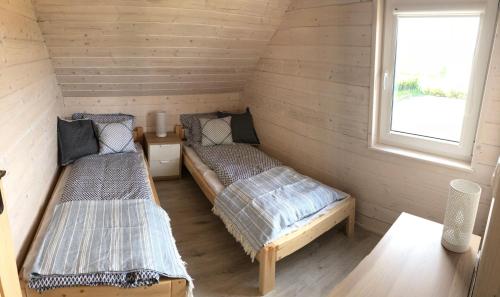 a room with two beds and a window at Ciche Wydmy in Sasino