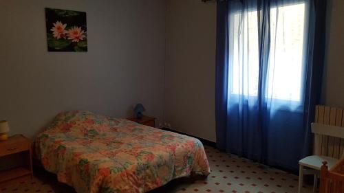 - une chambre avec un lit et une fenêtre avec un couvre-lit dans l'établissement La basse, à Saint-Remèze