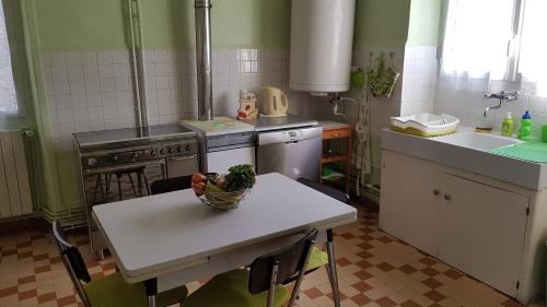 - une cuisine avec une table et un bol de légumes dans l'établissement La basse, à Saint-Remèze