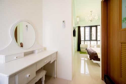 a white bathroom with a vanity and a mirror at Kaohsiung Raifong Corner Homestay in Kaohsiung