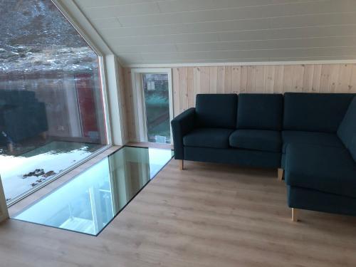 a living room with a couch and a window at Fisherman`s Cabin Lofoten in Ballstad