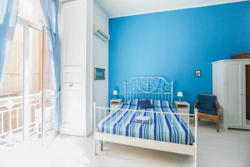 Dormitorio azul con cama y pared azul en Camera Con Vista Apartments, en Nápoles