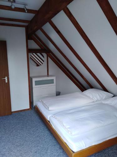 a bedroom with a white bed in a attic at Waldeck in Frankenau