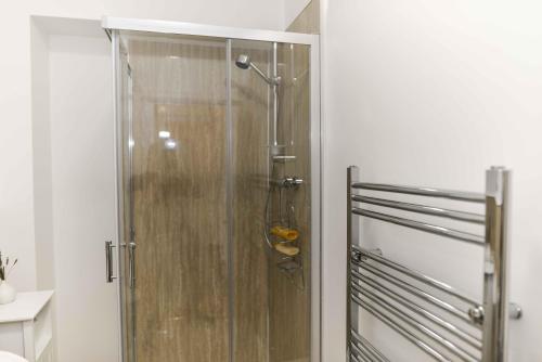 una ducha con puerta de cristal en un baño en Stafford Modern Apartment, en Aberdeen