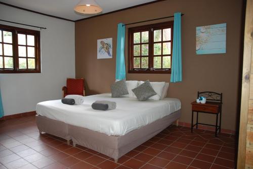 Un dormitorio con una gran cama blanca con cortinas azules. en Mirador Apartments, en Willemstad