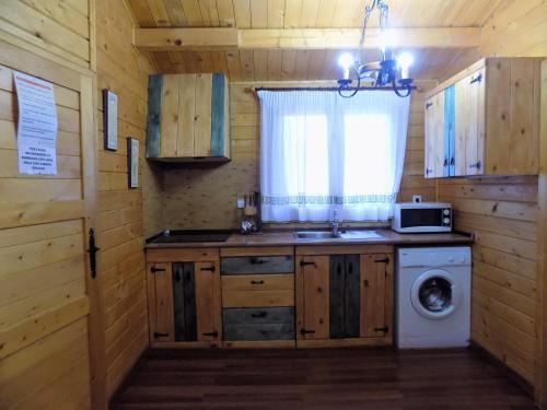 a kitchen with a sink and a washing machine at CABAÑAS DE MADERA LA FLORIDA in Arroyo Frio