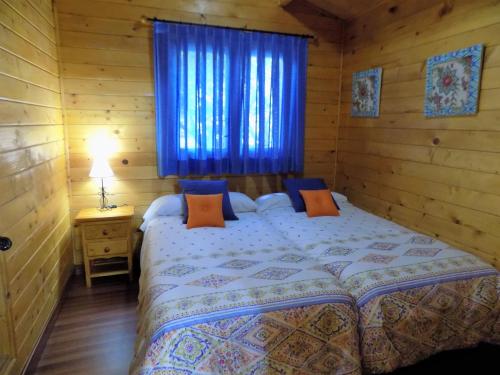 a bedroom with a bed with a blue window at CABAÑAS DE MADERA LA FLORIDA in Arroyo Frio