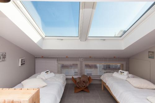 Cette chambre comprend 3 lits et une lucarne. dans l'établissement Loft 3 pièces duplex 3 étoiles calme centre ville à 5 mn des plages et palais, à Cannes