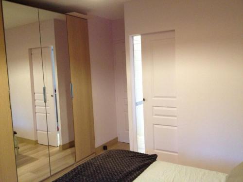 a bedroom with a closet and a glass door at Aux Perderies in Tréguier