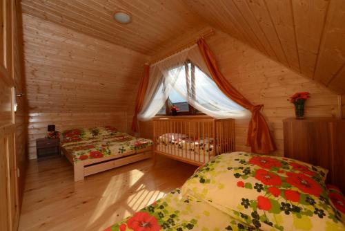 ゴンスキにあるLato Gąski Drewniane Domki Letniskoweの木造キャビン内のベッドルーム1室(ベッド2台付)
