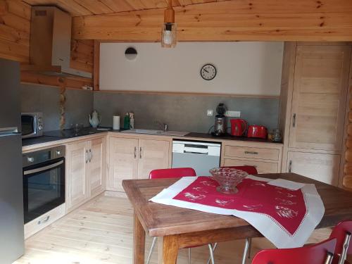 une cuisine avec une table en bois et des chaises rouges dans l'établissement Gîtes du Chêne Vert, à Montignac