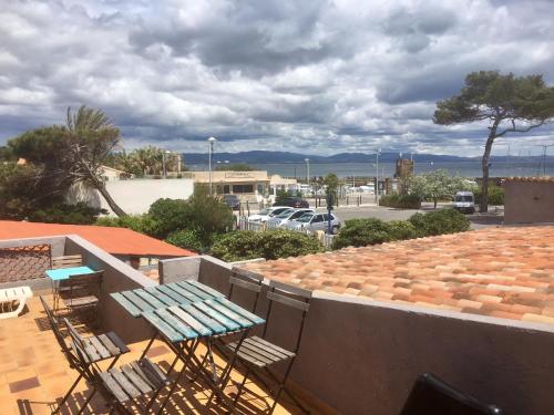 a patio with a table and chairs on a roof at Hôtel La Bastide in Hyères