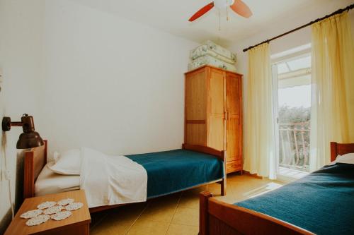 a bedroom with two beds and a window at Apartments Doulos in Splitska