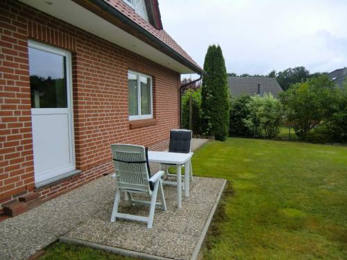 una mesa y dos sillas sentadas fuera de una casa en Ferienwohnung Jannsen, en Bad Bevensen