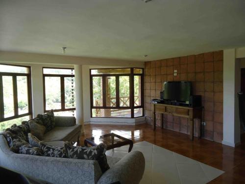 a living room with two couches and a tv at Villas Las Neblinas in Constanza