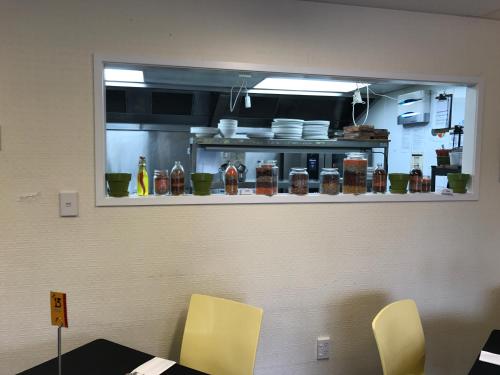 a mirror on the wall of a kitchen with a table and chairs at Heartland Ambassador Hotel Hamilton in Hamilton